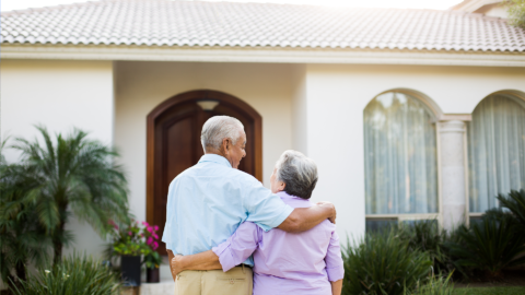 An elderly couple looking at their home